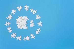 White jigsaw puzzle pieces on a blue background. Problem solving concepts. Texture photo with copy space for text