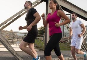 group of young people jogging across the bridge photo