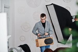 hombre que sostiene la grabadora handmande con altavoz bluetooth en el estudio. foto