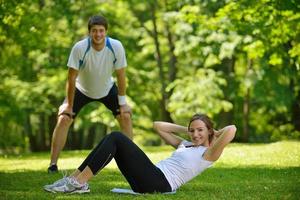 pareja haciendo ejercicio de estiramiento después de trotar foto