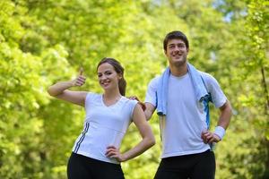 pareja haciendo ejercicio de estiramiento después de trotar foto