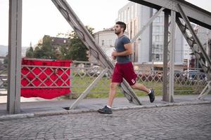 man jogging across the bridge at sunny morning photo