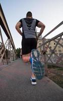 hombre corriendo por el puente en la mañana soleada foto