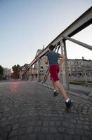 man jogging across the bridge at sunny morning photo