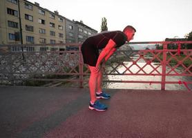 hombre corriendo por el puente en la mañana soleada foto