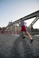 man jogging across the bridge at sunny morning photo