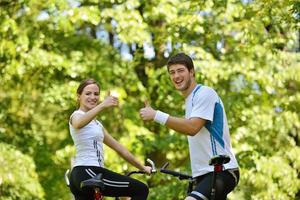 Happy couple riding bicycle outdoors photo