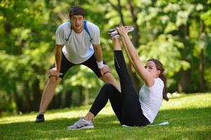 pareja haciendo ejercicio de estiramiento después de trotar foto