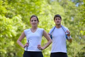 pareja haciendo ejercicio de estiramiento después de trotar foto