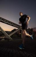 man jogging across the bridge in the city photo