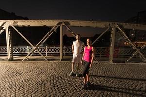 couple jogging across the bridge in the city photo