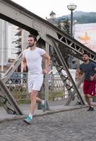 group of young people jogging across the bridge photo