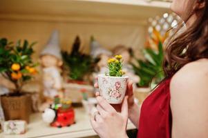 Brunette girl in red buy flowers at flower store. photo