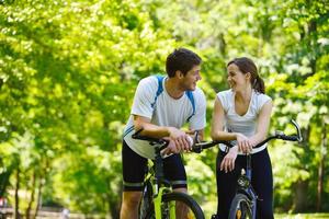 Happy couple riding bicycle outdoors photo