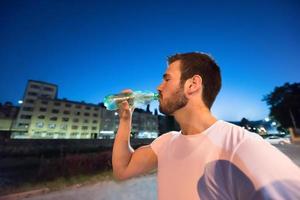 man drinking water after running session photo