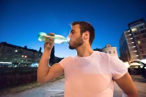 man drinking water after running session photo