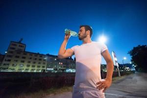 man drinking water after running session photo