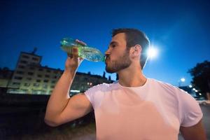 man drinking water after running session photo