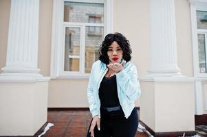 Stylish african american plus size model at streets of city on winter day. photo