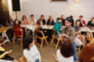 Master class and study concept. Abstract blurred photo of conference or seminar room with speaker on the stage.