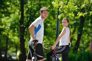 Happy couple riding bicycle outdoors photo