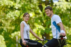 Happy couple riding bicycle outdoors photo