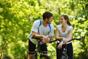 Happy couple riding bicycle outdoors photo