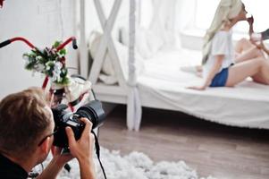 Man photographer shooting on studio two girls while they make their own masks cream. Professional photographer on work. photo