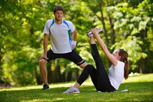 pareja haciendo ejercicio de estiramiento después de trotar foto