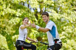 Happy couple riding bicycle outdoors photo