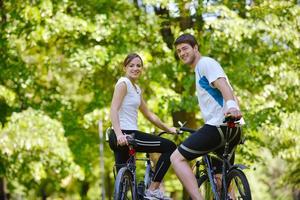 Happy couple riding bicycle outdoors photo