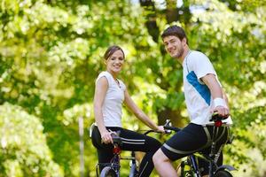 Happy couple riding bicycle outdoors photo