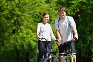 Happy couple riding bicycle outdoors photo