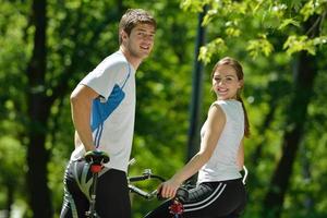 Happy couple riding bicycle outdoors photo