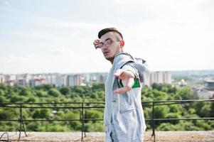 hombre macho con estilo soñador en traje gris y gafas posadas en el techo. foto