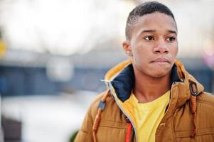 Close up portrait of african man wear on orange jacket at cold weather posed outdoor. photo