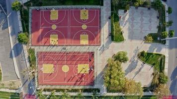 Aerial Shot Of Basketball Court. This stock video shows an aerial shot of people playing basketball on a court.