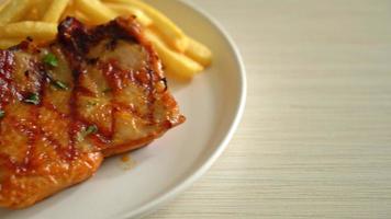 grilled chicken steak with potato chips or french fries on white plate