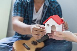 Couple holding model house, new house in hand and buying new house and moving together business and real estate concept. photo