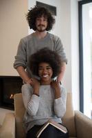 multiethnic couple hugging in front of fireplace photo