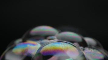 Soap bubbles isolated on black background. Abstract soap bubbles with colorful reflections. Soap bubbles in motion background. video