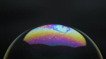 zeepbellen geïsoleerd op zwarte achtergrond. abstracte zeepbellen met kleurrijke reflecties. zeepbellen in beweging achtergrond. video