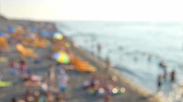 Static copy space blurry background tourist on crowded summer beach by sea relax. Intentional blur effect filter video