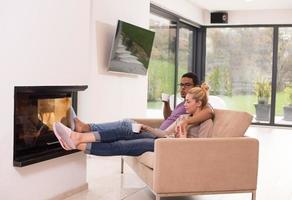 Young multiethnic couple  in front of fireplace photo