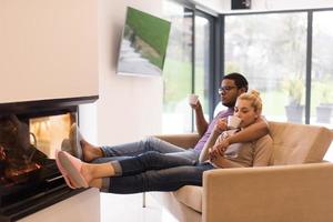 Young multiethnic couple  in front of fireplace photo