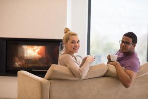 Young multiethnic couple  in front of fireplace photo