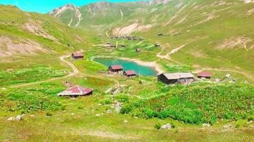 Aerial zoom out view Shuamta small lake surrounded by mountain village wooden houses in high Adjara video