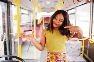 joven mujer afroamericana con estilo montando en un autobús. foto