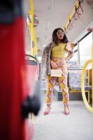 Young stylish african american woman in modern sunglasses riding on a bus. photo