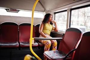 joven mujer afroamericana con estilo montando en un autobús. foto